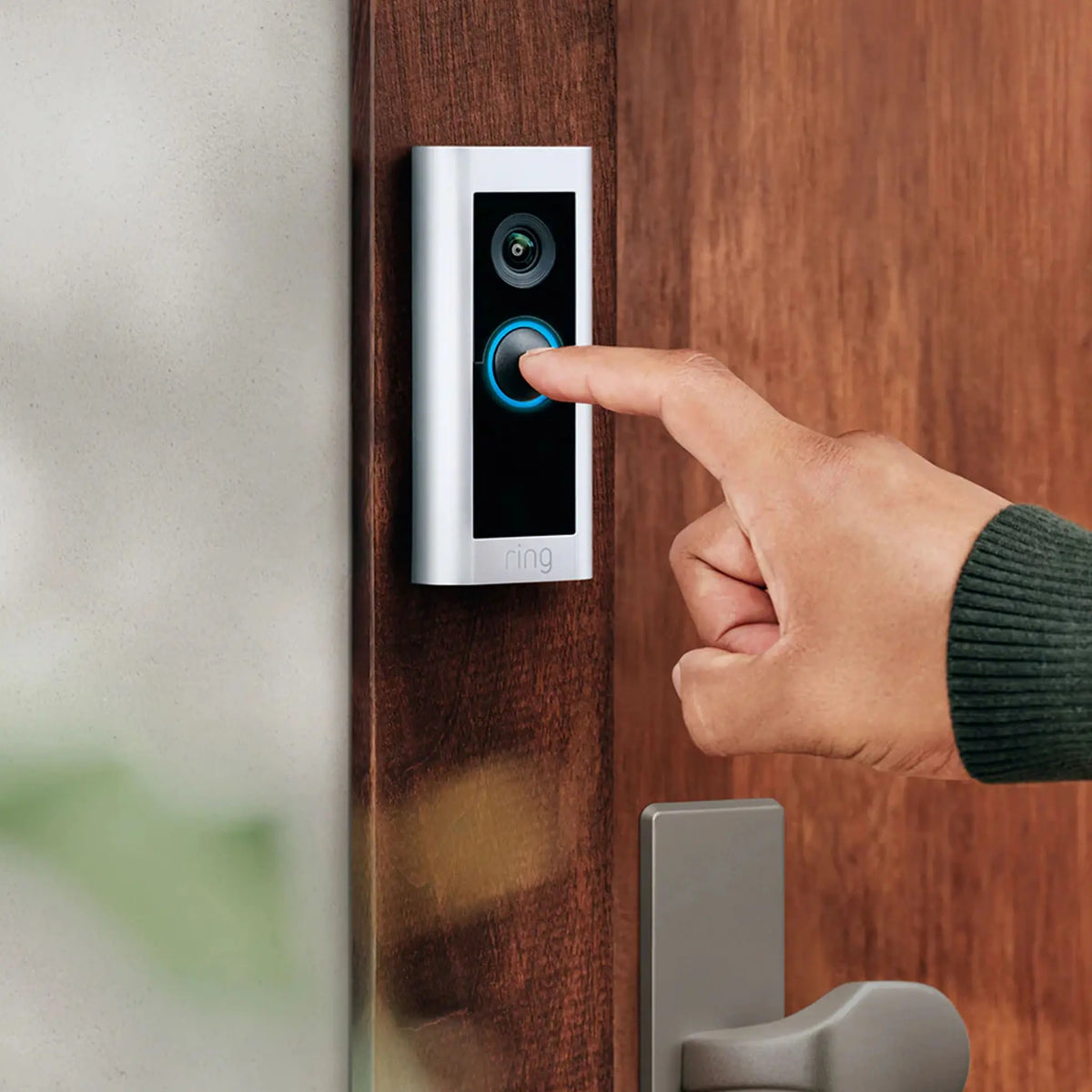 Ring Doorbell Pro 2 Plug-In mounted on wooden door frame with button being pressed